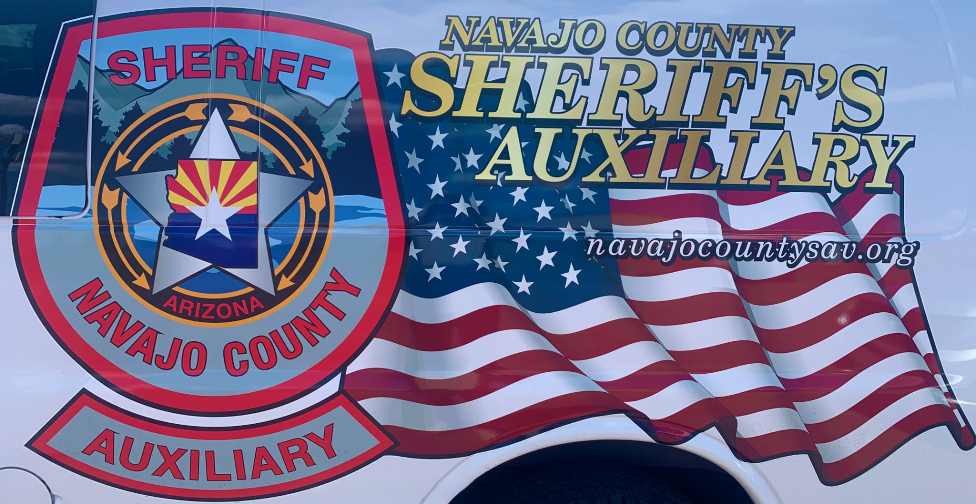 Navajo County Sheriff's Auxiliary vehicle graphic showing the Arizona sheriff badge, American flag, and navajocountysav.org